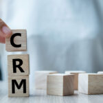 Business woman hand holding wooden cube with CRM text (Customer