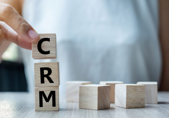 Business woman hand holding wooden cube with CRM text (Customer