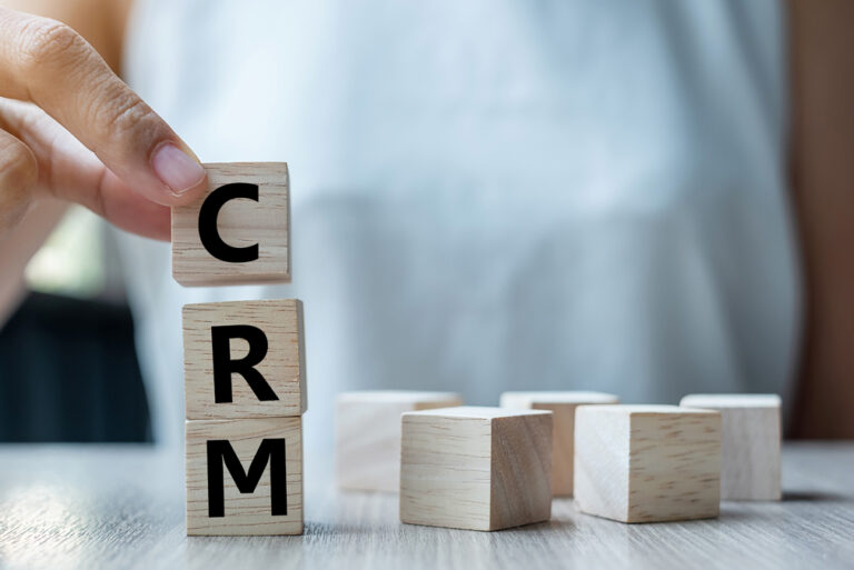 Business woman hand holding wooden cube with CRM text (Customer